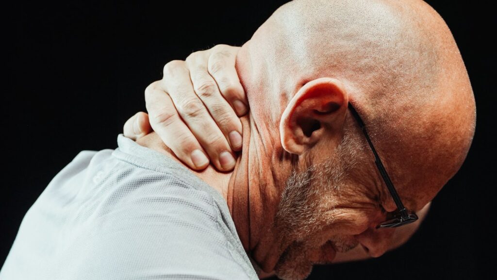 a man holding his neck suffering from neuropathic pain